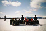 Members of the team standing next to their ATVs.